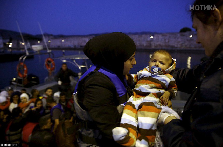 2915085500000578-3097559-A_Greek_coastguard_officer_right_passes_seven_month_old_Syrian_r-a-5_1432660184532