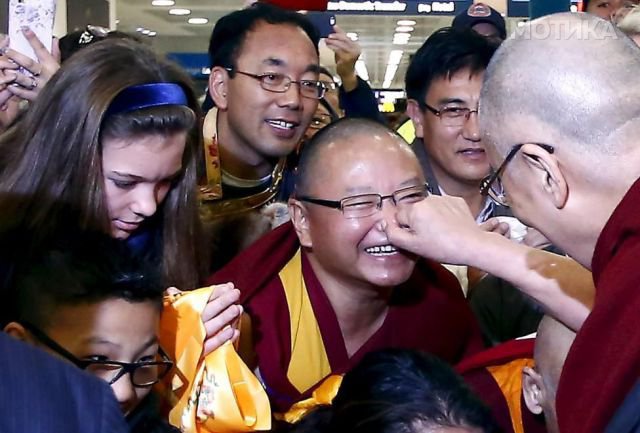 Exiled Tibetan spiritual leader the Dalai Lama pinches the nose of a supporter after arriving at Sydney International airport