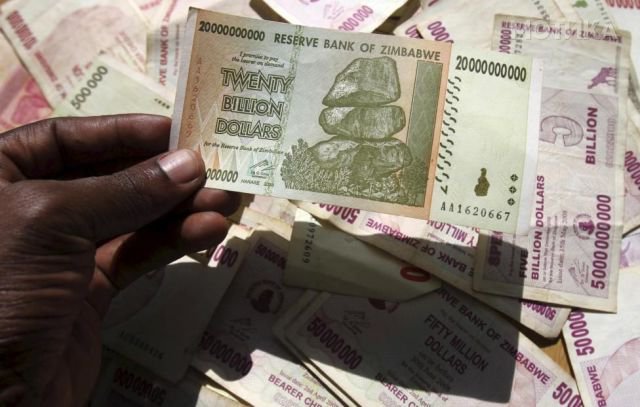 A man poses with Zimbabwean bank note at a bank in central Harare