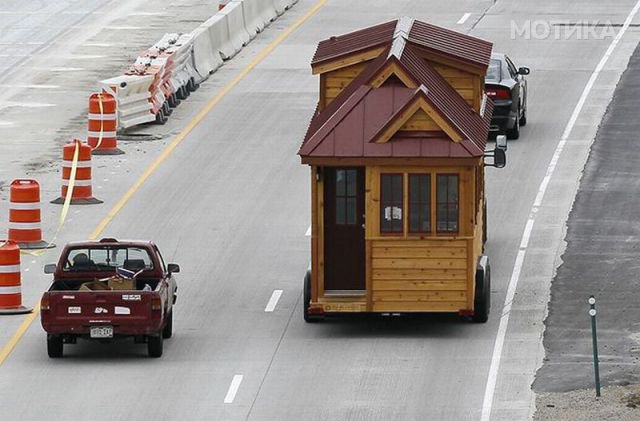 A Tumbleweed brand Cypress 24 model Tiny House is towed down the highway near Boulder
