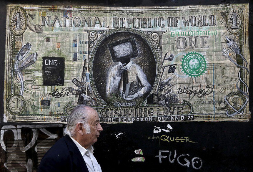 A man walks past a graffiti illustrating a modified dollar banknote in Athens
