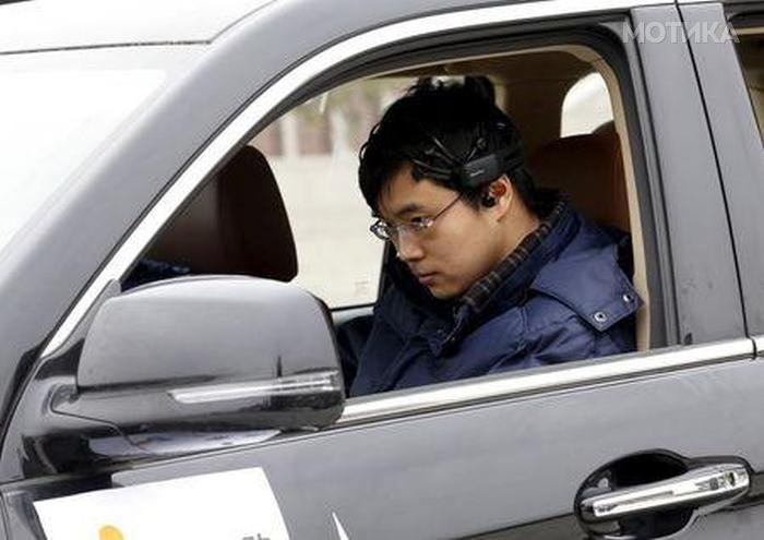 Researcher Zhang Zhao wearing a brain signal-reading equipment prepares to move a car with his brain wave, during a demonstration at Nankai University in Tianjin