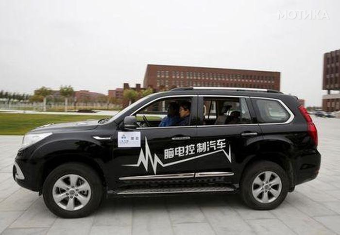 Researcher Zhang Zhao wearing a brain signal-reading equipment moves a car forward with his brain wave during a demonstration at Nankai University in Tianjin