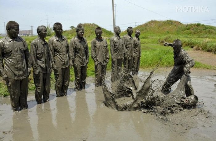 Paramilitary policemen practice combat during a training session in muddy water at a military base in Chuzhou