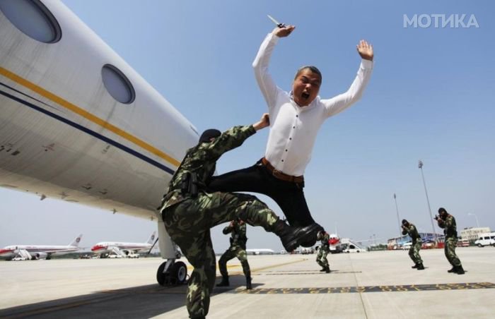 A paramilitary policeman knocks down a man role-playing as a plane hijacker during an anti-terrorism drill at Nanjing Lukou International Airport in Nanjing